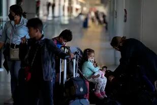 Una familia que regresa a casa a Panamá después de pasar tres semanas en Estados Unidos llega al aeropuerto internacional de Miami antes de su vuelo, el lunes 27 de diciembre de 2021. (AP Foto/Rebecca Blackwell)