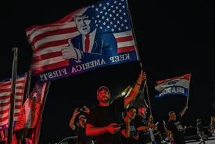 Suppoerters of former US President Donald Trump stand outside his residence residence in Mar-A-Lago, Florida on August 8, 2022. - Former US president Donald Trump said August 8, 2022 that his Mar-A-Lago residence in Florida was being "raided" by FBI agents in what he called an act of "prosecutorial misconduct." (Photo by Giorgio VIERA / AFP)