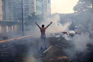Un joven, brazos en alto, frente a la Guardia Nacional Bolivariana, ayer, en Caracas
