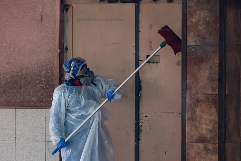 Un trabajador de limpieza desinfecta el sector de ambulancias afuera de un hospital en Santiago, el 6 de julio de 2020, en medio de la pandemia de coronavirus