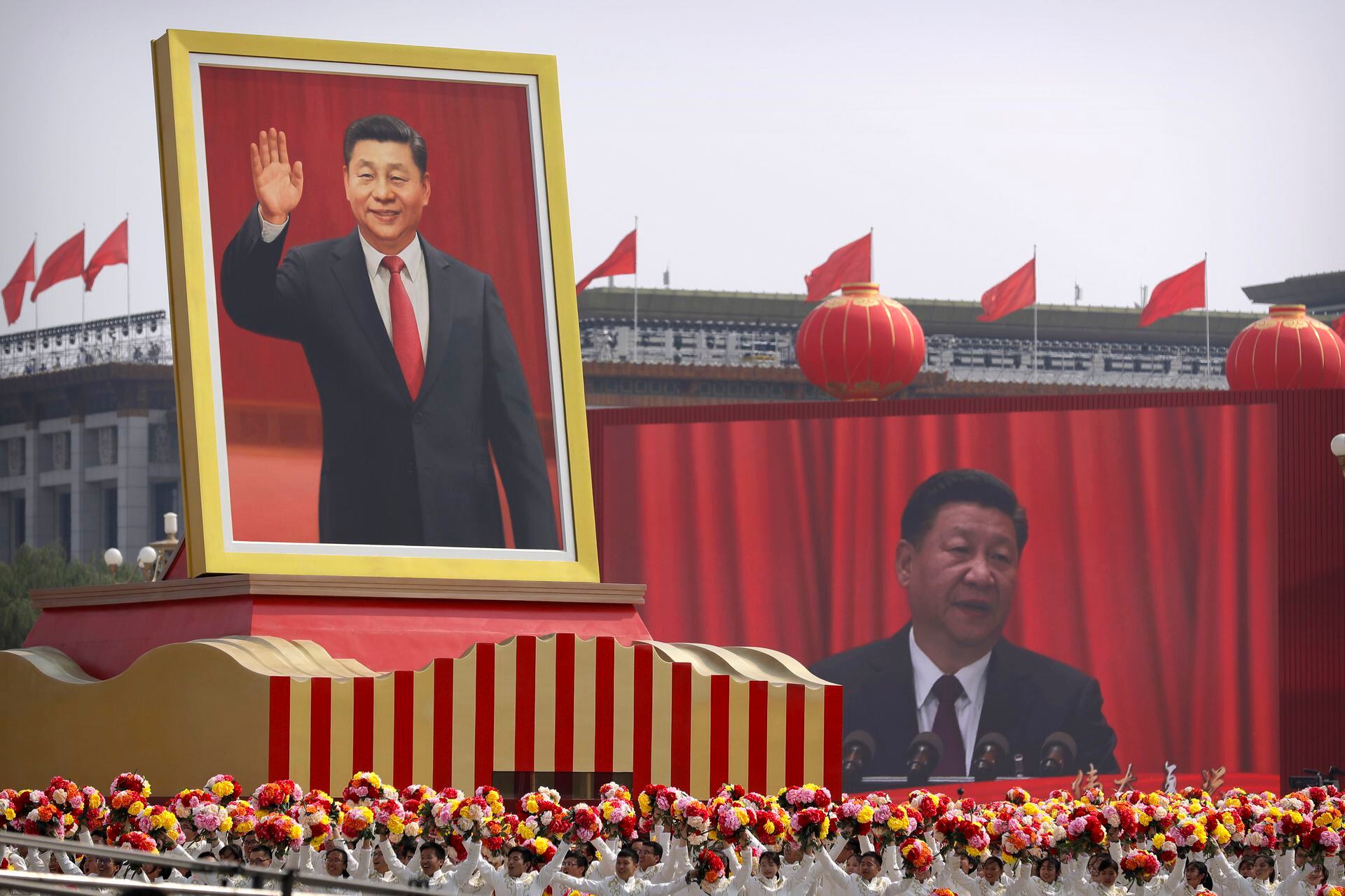 En esta imagen del 1 de octubre de 2019, participantes vitorean bajo un gran retrato del presidente de China, Xi Jinping, durante un desfile por el 70mo aniversario de la fundación del Partido Comunista Chino, en Pekín