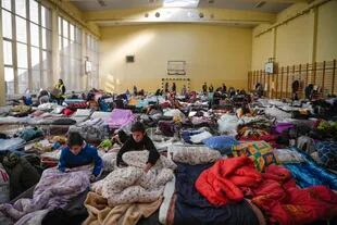 Unos niños descansan en un refugio temporal para refugiados ucranianos en una escuela de Przemysl, cerca de la frontera ucraniana-polaca, el 14 de marzo de 2022.