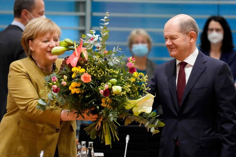 TOPSHOT - German Chancellor Angela Merkel (L) receives a bouquet of flowers from German Finance Minister, Vice-Chancellor and the Social Democrats (SPD) candidate for Chancellor Olaf Scholz prior to the cabinet meeting at the Chancellery in Berlin, Germany, on November 24, 2021. - Merkel was given flowers as this was probably her last cabinet session as German Chancellor as negotiations are going on to form a new government after elections were held in September. (Photo by Markus Schreiber / POOL / AFP)