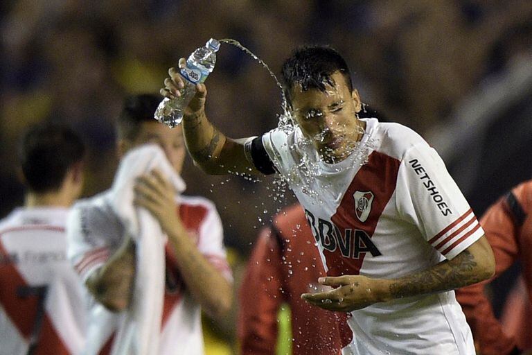 Argentinas River Plate defender Leonel Vangioni pours water on his face after receiving tear gas before the start of the second time of the Copa Libertadores 2015 round before the quarterfinals second leg football match against Argentinas Boca Juniors at the &quot;Bombonera&quot; stadium in Buenos A