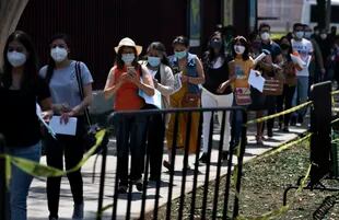 Educadoras hacen fila para que les pongan la vacuna de CanSino contra el COVID-19 en el Instituto Politécnico Nacional en la Ciudad de México