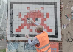 Olivier Moquin, personal de seguridad, limpia la obra “PA_758, 2008” del artista que se conoce con el nombre de Invader en París