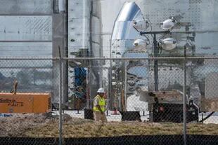 Un trabajador camina por la base de un prototipo de nave espacial Starship de SpaceX en las instalaciones de lanzamiento de la compañía en Texas