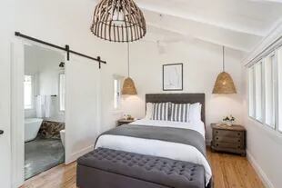 En el dormitorio, lámparas colgantes en fibras naturales y ropa de cama en confortable lino.
