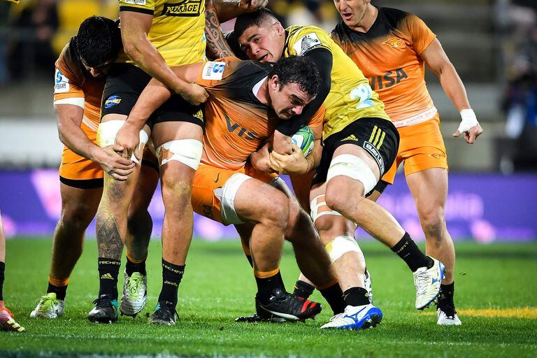 Agustin Creevy of the Jaguares (C) is tackled during the Super Rugby match between Argentinas Jaguares and New Zealands Hurricanes at Westpac Stadium in Wellington on May 17, 2019. (Photo by MARK TANTRUM / AFP)