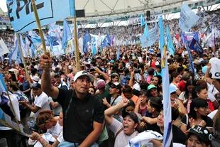 Banderas y militantes de Barrios de Pie, en el campo de juego del estadio platense