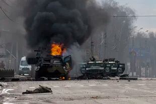 Un vehículo blindado de transporte de personal se quema y los vehículos utilitarios ligeros dañados quedan abandonados después de los combates en Kharkiv.