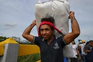 Un hombre venezolano camina por el puente internacional Simón Bolívar mientras regresa a San Antonio del Táchira, en Venezuela, después de comprar productos en Cúcuta, Colombia, el 26 de septiembre de 2022.