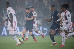 Lionel Messi conduce el balón y es observado atentamente por los jugadores de Lyon