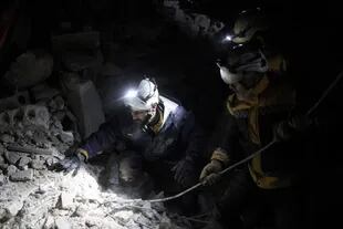 Miembros de los Cascos Blancos trabajan para salvar a las personas atrapadas bajo un edificio destruido en la ciudad de Harem tras el devastador terremoto que sacudió la frontera turco-siria y dejó más de 5000 muertos.
