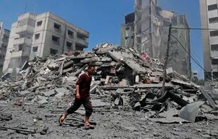 Un hombre camina por los escombros de un edificio destruido por un ataque de Israel en Gaza, el 16 de mayo de 2021. (AP Foto/Adel Hana)