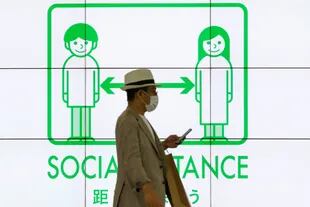 "Distancia social": uno de los carteles de Tokio en plena pandemia