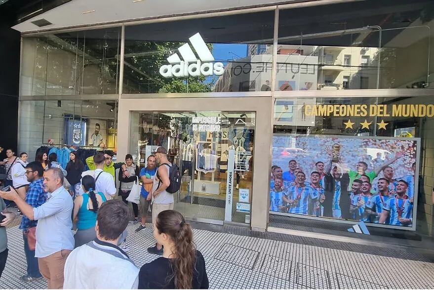 Varias personas hacen cola en un local de ropa deportiva en Palermo para comprar la camiseta de la Selección con las tres estrellas