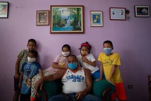 Una familia posa para un retrato en su apartamento del barrio La Lira, de Caracas, durante la pandemia Covid-19. Por @andrernandez