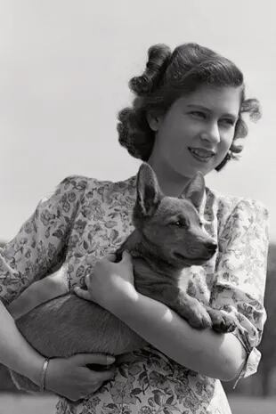 1940s: Isabel sonríe con su corgi, Jane. La joven princesa quedó devastada cuando su mascota murió atropellada por un auto. A pesar del terrible accidente, ella le escribió al conductor para decirle que él no había tenido la culpa