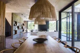 Mesa con tapa de kiri lustrado diseñada por la dueña de casa. Sillas estilo ‘Wishbone’. Lámparas colgantes (La Ferme).