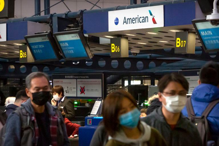 ARCHIVO - Viajeros se forman en un mostrador de American Airlines para documentar para un vuelo de Los Ángeles a Beijing, el jueves 30 de enero de 2020. (AP Foto/Mark Schiefelbein, Archivo)