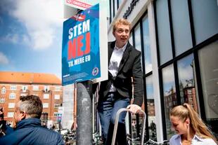 El presidente del Partido Popular Danés, Morten Messerschmidt, cuelga un cartel con la leyenda en danés "Vota no a más UE", en Amagerbro en Copenhague, el sábado 7 de mayo de 2022. 