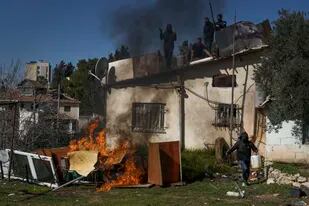 Un grupo de palestinos resiste el intento de las autoridades israelíes de sacarlos de una propiedad disputada en el vecindario Sheikh Jarrah de Jerusalén oriental, el 17 de enero de 2022.   (Foto AP/Mahmoud Illean)