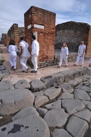 Los visitantes caminan por la adoquinada Vía del Vesubio. Tras la erupción del Volcán en el año 79 d.C., la ciudad quedó cubierta por un espeso extracto de piedras y cenizas volcánicas