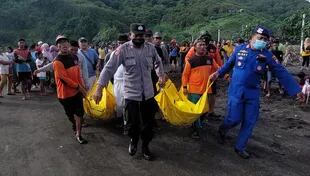 Un equipo de búsqueda y rescate lleva cadáveres luego de un accidente en un ritual en una playa de Indonesia