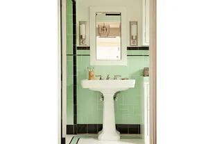 En el baño, los antiguos azulejos traen vitalidad a un ambiente con muebles sobrios y detalles clásicos