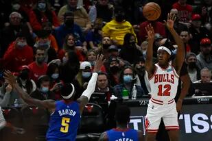 El base de los Bulls de Chicago Ayo Dosunmu lanza durante la segunda mitad del partido de la NBA contra los Nuggets de Denver, el lunes 6 de diciembre de 2021, en Chicago. (AP Foto/Matt Marton)
