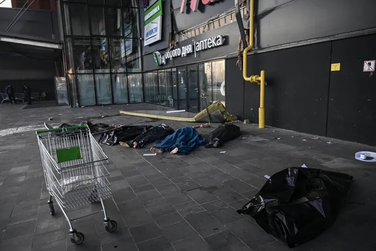 Following the Russian missile attack on Kiev on March 21, 2022, the bodies of Ukrainian soldiers were wrapped in blankets and plastic bags outside a retail shopping center.