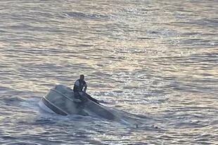 Fotografía divulgada por la sección Sureste de la Guardia Costera estadounidense donde se aprecia a un sobreviviente de un naufragio aferrado en un bote frente de la costa de Fort Pierce, a unos 240 kilómetros al norte de Miami.
