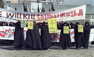 En esta foto de archivo tomada el 17 de febrero de 1989, se ve a mujeres iraníes sosteniendo pancartas que decían "Holly Koran" y "Kill Salman Rushdie" durante una manifestación contra el escritor británico Salman Rushdie en Teherán
