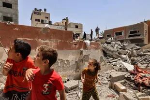 Niños en la ciudad de Gaza observan este sábado los daños causados por un ataque israelí