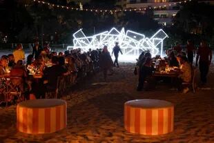 Sobre la playa de Miami, en el cumpleaños de Alan Faena, los invitados a la fiesta pudieron contemplar la escultura lumínica "Patria y vida" (al fondo), hecha por dos artistas cubanoamericanos en el marco de la Miami Art Week