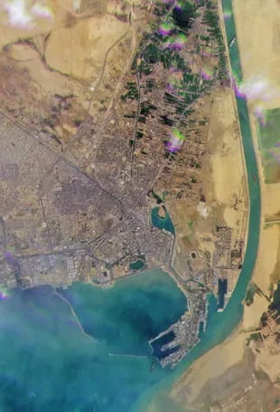 Una imagen de un folleto satelital publicada por Planet Labs Inc el 24 de marzo de 2021 muestra el buque portacontenedores de 400 metros MV Ever Given alojado de lado e impidiendo todo el tráfico a través del Canal de Suez. Los egipcios no creían tener capacidad para que el país pudiese destrabarlo