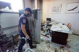 Policías evalúan los daños producidos por las llamas en la Legislatura provincial. Se estima que en los edificios públicos atacados la reparación costará más de 50 millones de pesos.