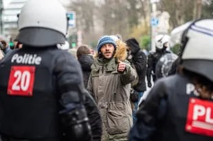 Un hombre se enfrenta a la policía durante una manifestación contra las restricciones de Covid-19 el 14 de febrero de 2022, en Bruselas, Bélgica.