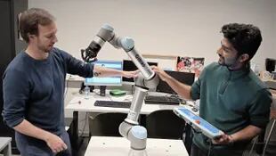 Pablo Lanillos, coordinador del proyecto Metatool, (a la izquierda) y el investigador postdoctoral Ajith Anil Meera trabajan con uno de sus robots industriales
