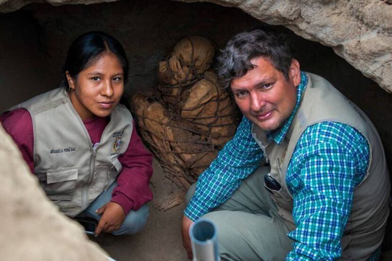 Los arqueólogos Yomira Silvia Huamán Santillán y Pieter Van Dalen, responsables del Proyecto Cajamarquilla, posan delante de la momia hallada recientemente en ese complejo arqueológico