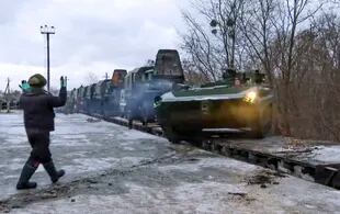 En esta imagen, tomada de un video distribuido por la oficina de prensa del Ministerio de Defensa de Rusia, vehículos blindados rusos circulan por un andén ferroviario a su llegada a Belarús