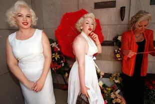 Imitadoras de la legendaria estrella de la pantalla Marilyn Monroe posan frente a la tumba de Monroe en el Westwood Village Memorial Park
