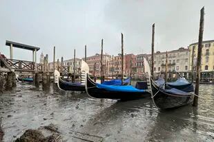 Las góndolas están ancladas a lo largo de un canal durante una marea baja en Venecia, Italia, el sábado 18 de febrero de 2023