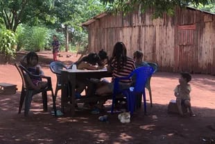 En la comunidad Yryapú, en Iguazú, Misiones, los chicos hacen la tarea de la escuela a la sombra. Como no tienen conectividad, usan cuadernos y fotocopias.