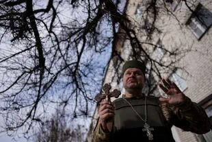 Chaplain Dmitri speaks to his neighbors Friday, April 8, 2022 in Bucha, near Kyiv, Ukraine.  (AP Photo/Rodrigo Abd)