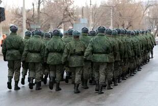 Militares marchan al salir de una ceremonia conmemorativa para honrar la memoria de los civiles que murieron durante un bombardeo en una parada de autobús abarrotada en 2015, en Donetsk, controlada por separatistas respaldados por Rusia, en el este de Ucrania, el sábado 22 de enero de 2022.