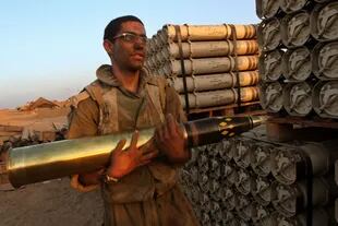 Un soldado israelí se prepara para introducir un cohete explosivo como carga de un tanque en las afueras de Gaza