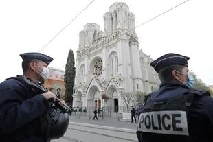 Policías franceses vigilan el sitio de un ataque con cuchillo en la Basílica de Notre-Dame de Niza en Niza el 29 de octubre de 2020, mientras los oficiales forenses se preparan para ingresar