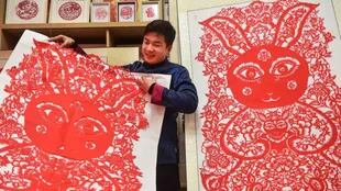 Un artista muestra una obra de arte de papel con 106 conejos para dar la bienvenida al Año Nuevo Chino.